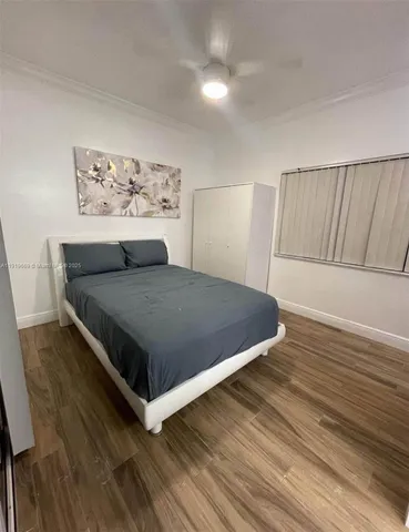 a view of a bedroom with furniture and wooden floor
