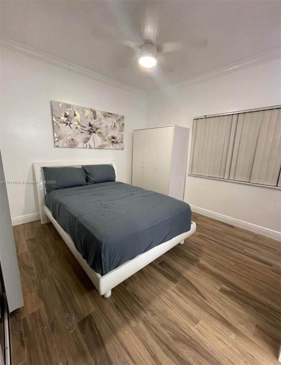 a view of a bedroom with furniture and wooden floor