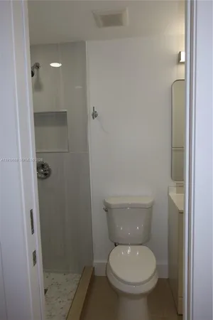 a white toilet sitting next to a shower