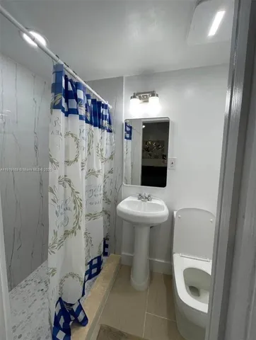 a bathroom with a toilet sink and mirror