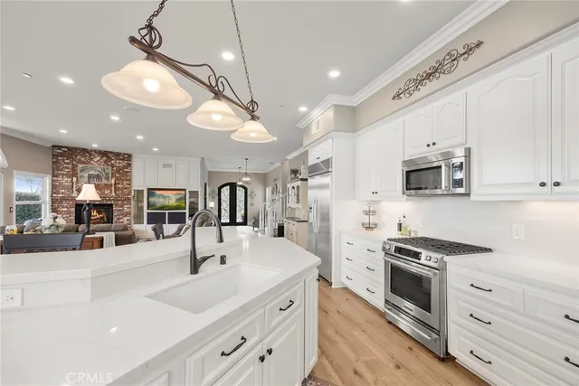 a view of a dining room and livingroom with furniture large windows a chandelier