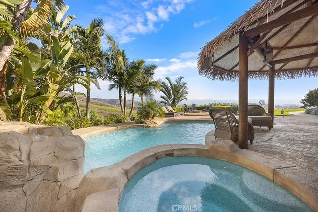 a view of a patio with table and chairs under an umbrella with a small yard