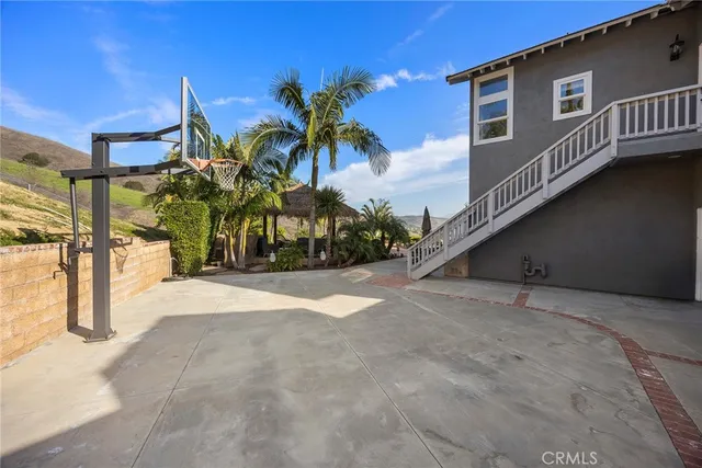 a view of a white house with a big yard and potted plants