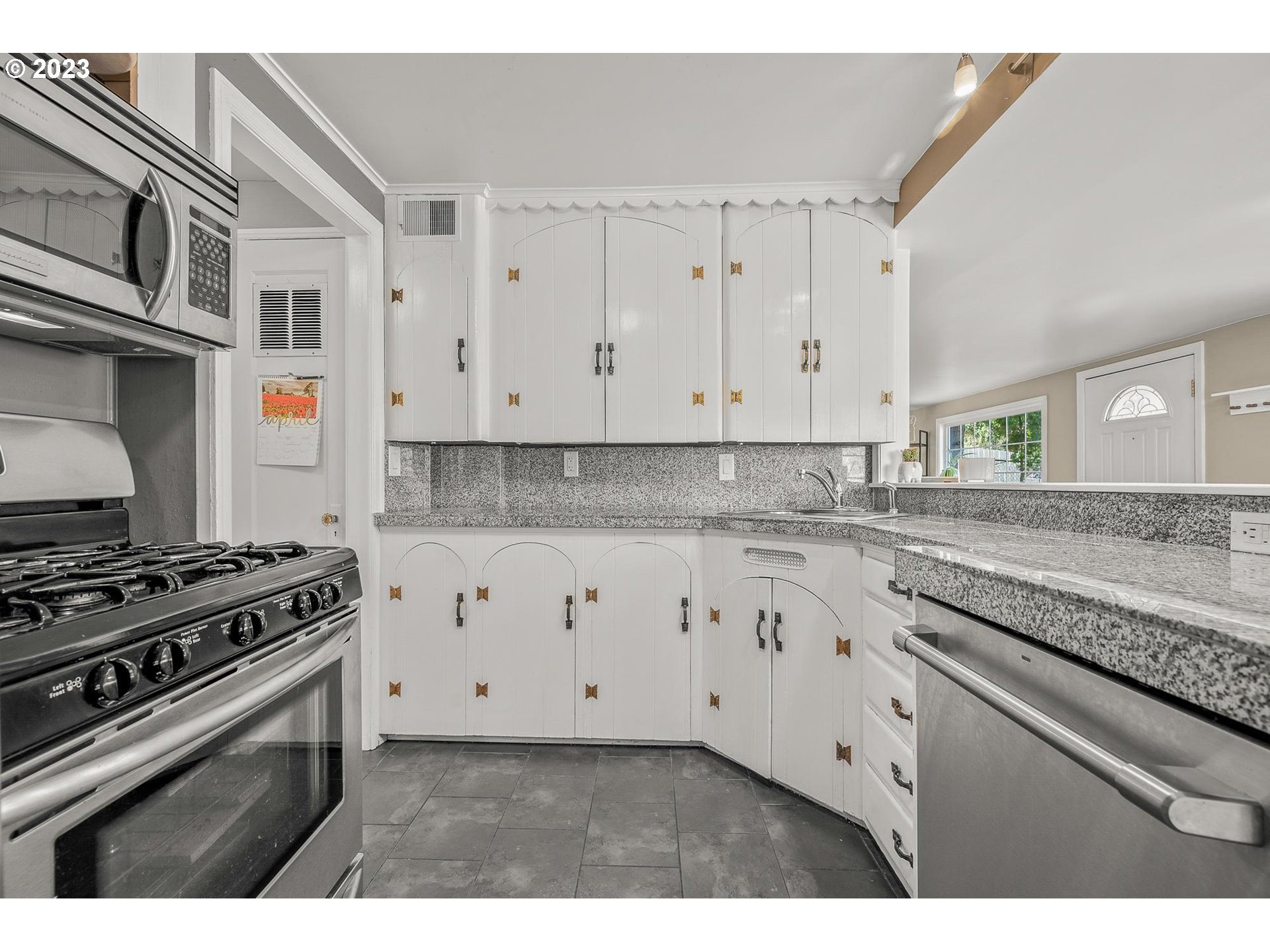 4052 Southwest Huber Street Portland, OR 97219 - Photo 15 of 48 a kitchen with granite countertop white cabinets and appliances