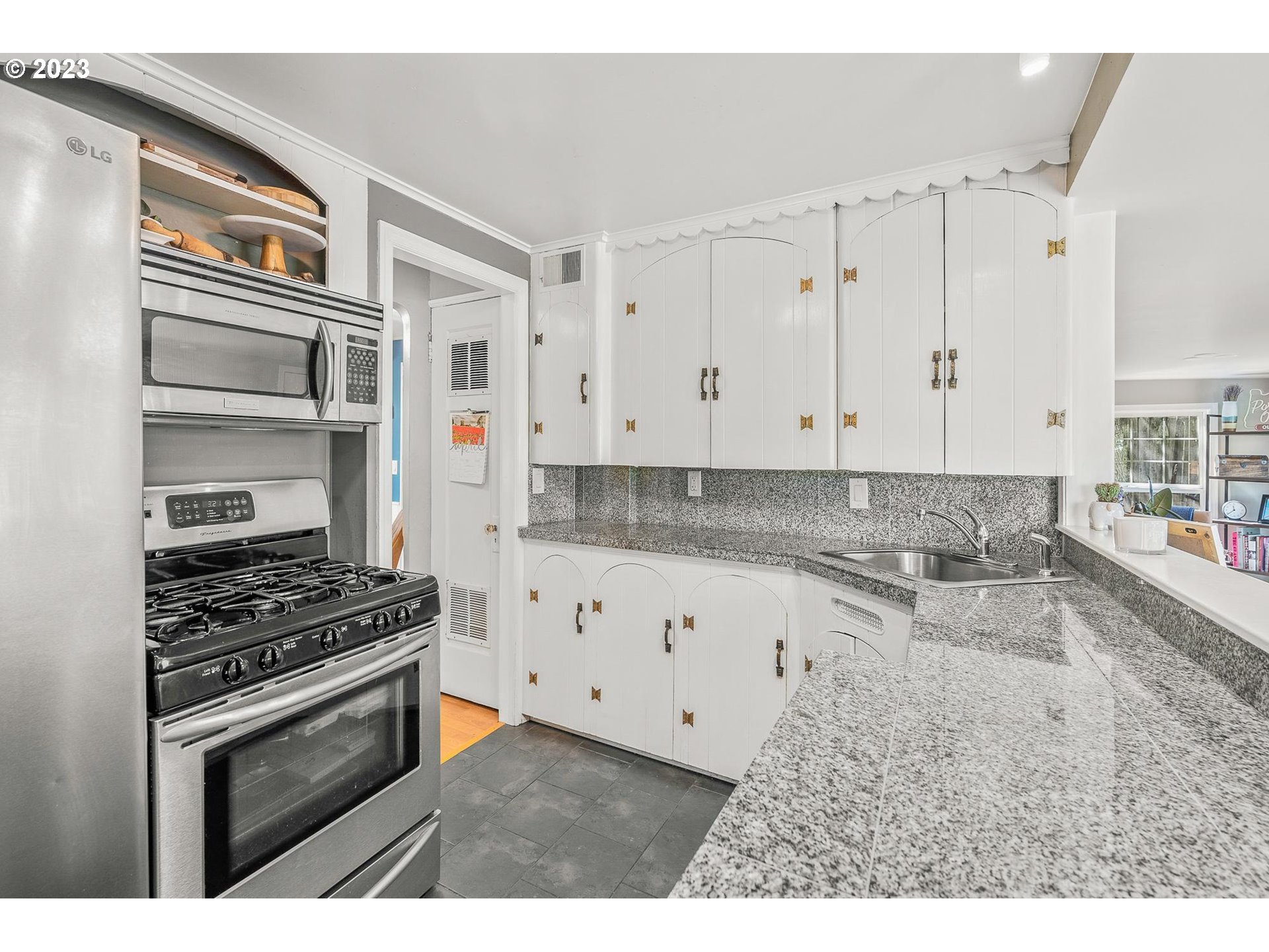 4052 Southwest Huber Street Portland, OR 97219 - Photo 17 of 48 a kitchen with granite countertop a stove and a sink