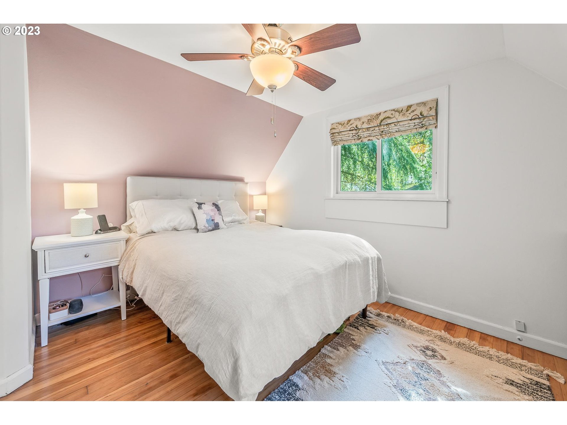 4052 Southwest Huber Street Portland, OR 97219 - Photo 27 of 48 a bedroom with a bed and a chandelier fan