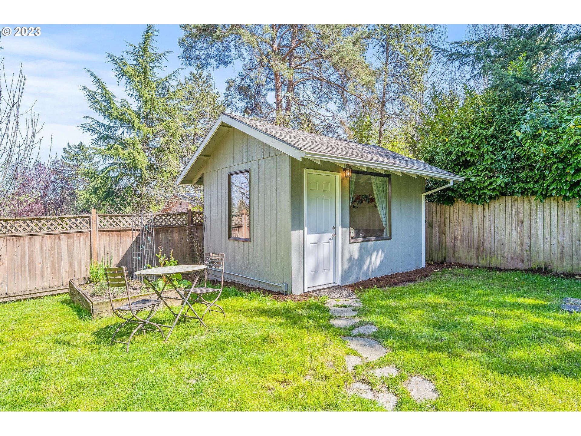 4052 Southwest Huber Street Portland, OR 97219 - Photo 36 of 48 a backyard of a house with table and chairs