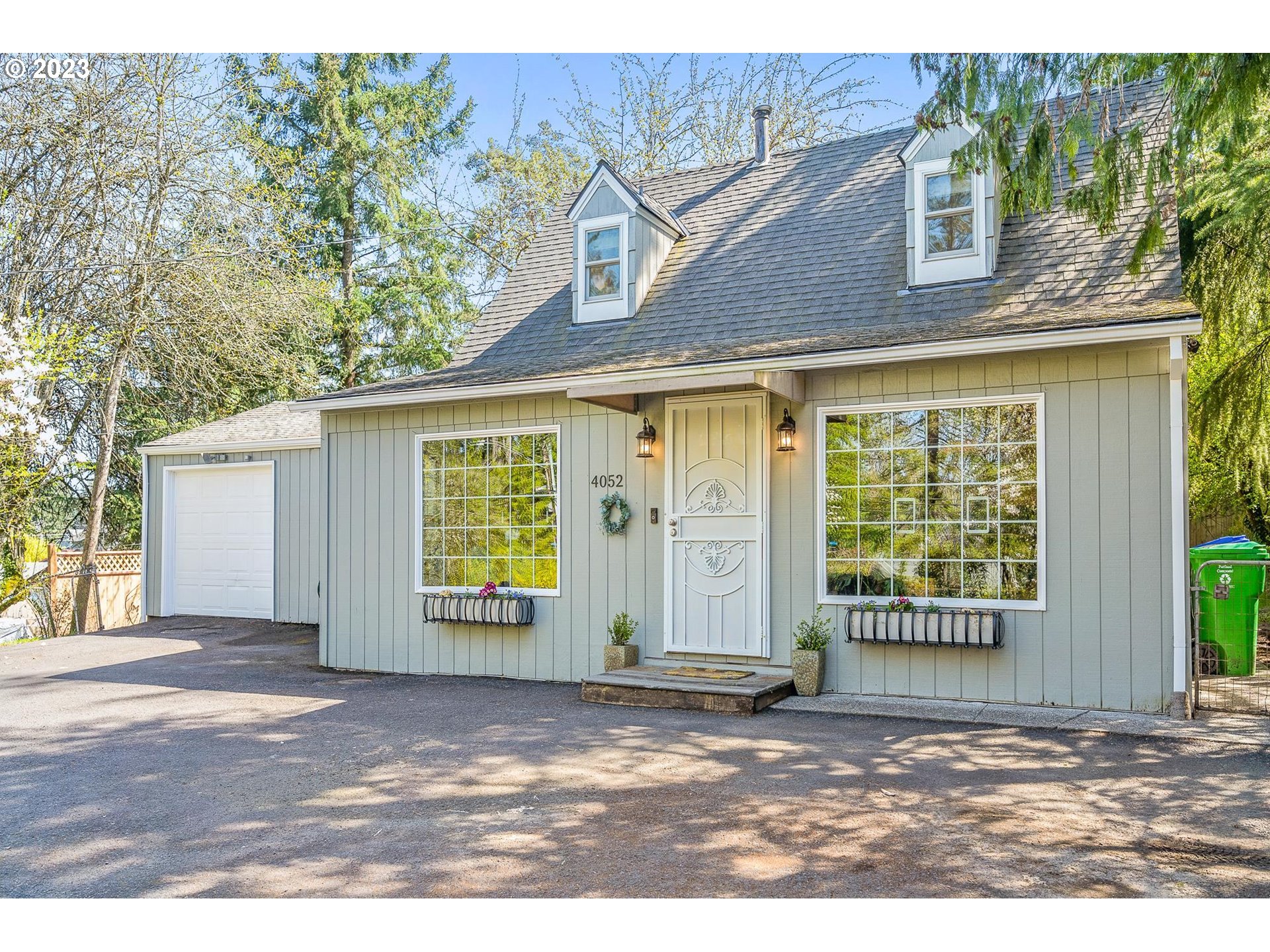 4052 Southwest Huber Street Portland, OR 97219 - Photo 4 of 48 a front view of a house with a garden