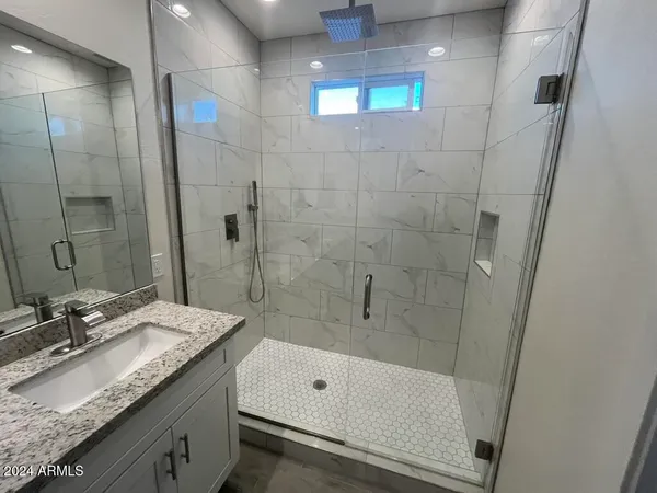 a bathroom with a granite countertop sink a toilet and shower