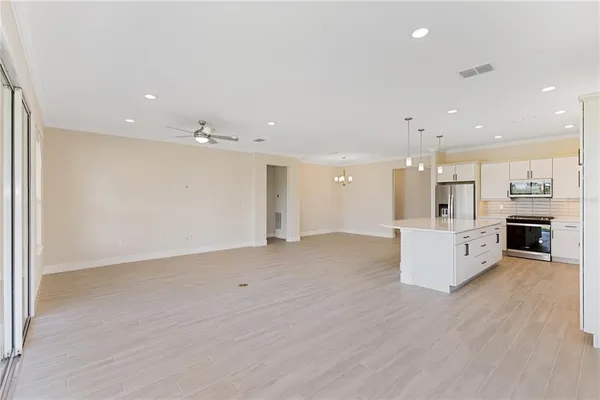 a view of an empty room with cabinet and a ceiling fan