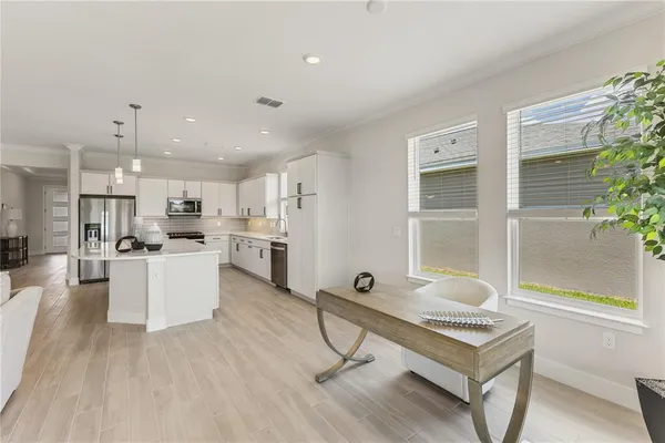 a large kitchen with granite countertop a large counter top a sink stainless steel appliances and cabinets