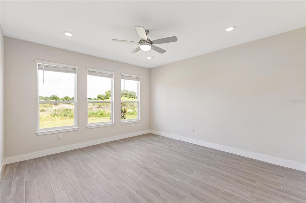 4473 Northwest 53rd Avenue Road Ocala, FL 34482 - Photo 19 of 40 an empty room with wooden floor fan and windows