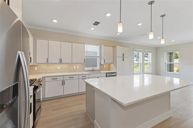 a large kitchen with kitchen island a sink appliances and a counter top space