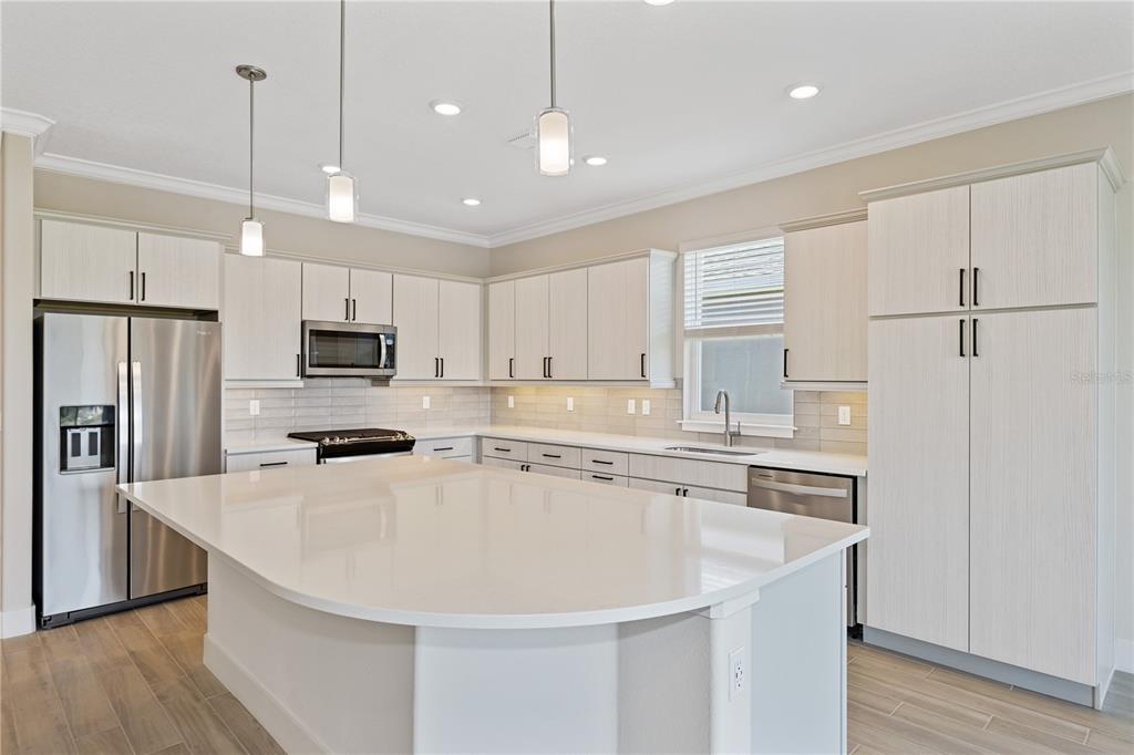 4473 Northwest 53rd Avenue Road Ocala, FL 34482 - Photo 3 of 40 a kitchen with kitchen island a sink stainless steel appliances and refrigerator