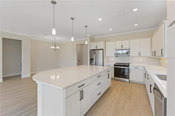 a kitchen with kitchen island a sink stainless steel appliances and cabinets
