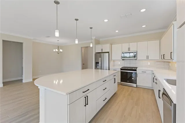 a kitchen with kitchen island a sink stainless steel appliances and cabinets