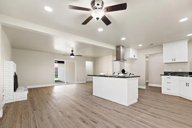 a kitchen with stainless steel appliances kitchen island hardwood floor sink stove and wooden floor
