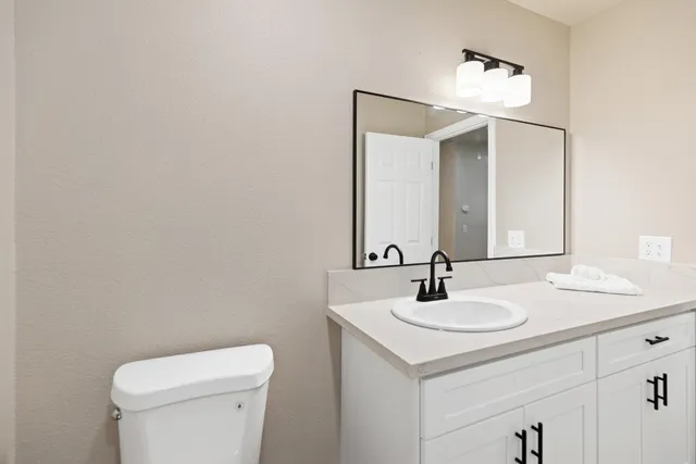 a bathroom with a sink a toilet and mirror