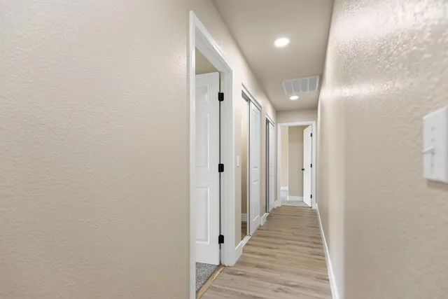 a view of a hallway with wooden floor and staircase