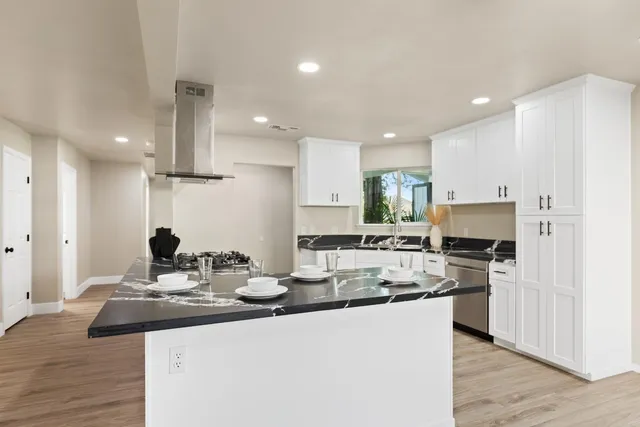 a kitchen with stainless steel appliances kitchen island granite countertop a sink and cabinets