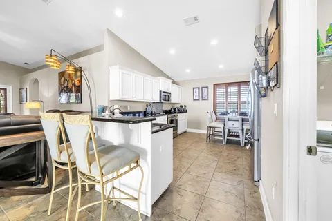 a kitchen with granite countertop lots of white cabinets and a stainless steel appliances