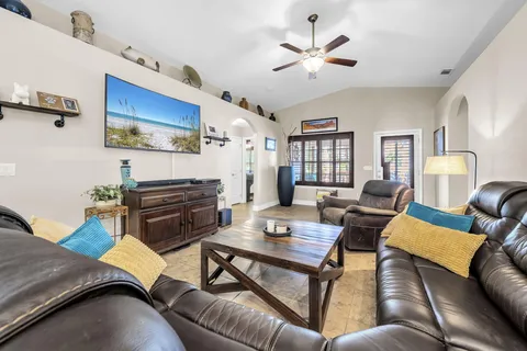 a living room with furniture a ceiling fan and a rug