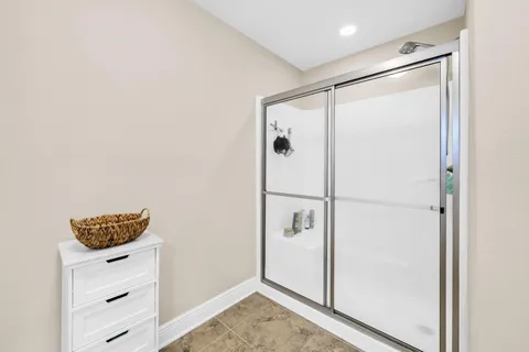 a bathroom with a shower and a glass door