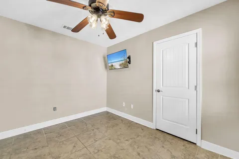 an empty room with closet and a chandelier fan