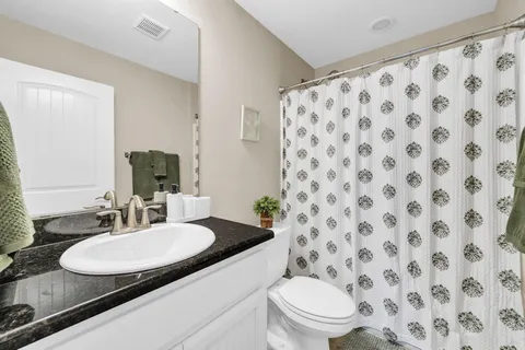 a bathroom with a granite countertop sink and a mirror