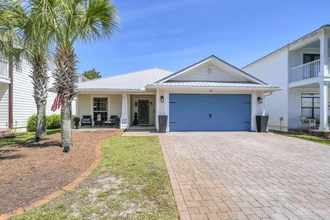 a view of a house with a yard and large tree