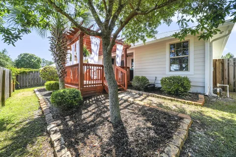 a view of a house with backyard and a tree