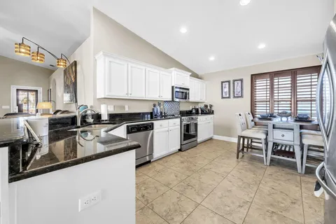 a kitchen with stainless steel appliances granite countertop sink stove top oven and cabinets