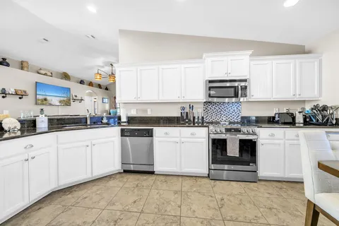 a kitchen with stainless steel appliances granite countertop a sink and cabinets