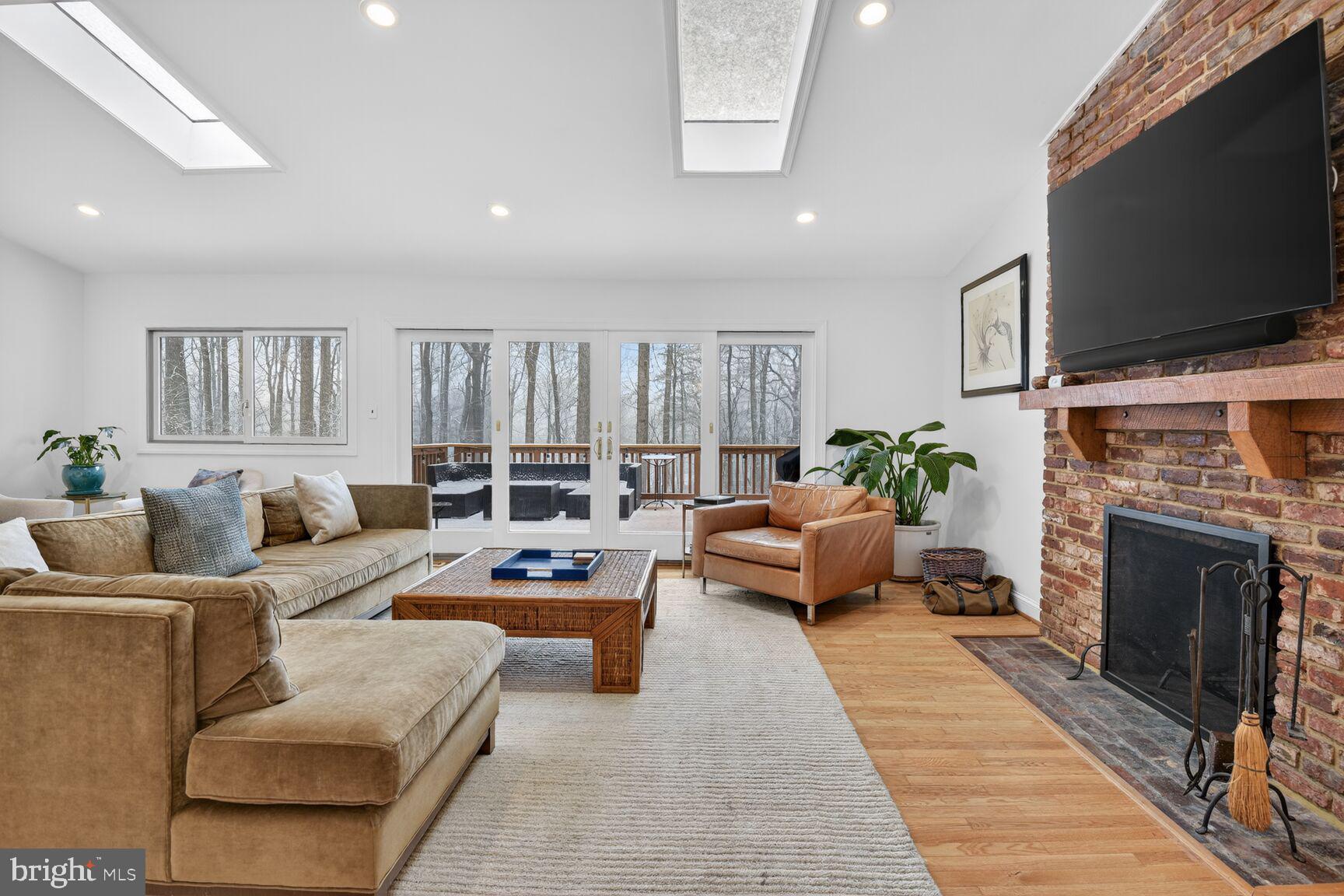 10209 Lloyd Road Potomac, MD 20854 - Photo 8 of 29 a living room with furniture a flat screen tv and a fireplace