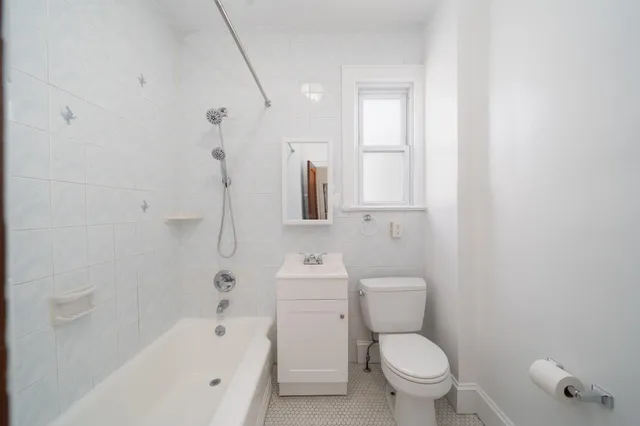 a white toilet sitting next to a bath tub