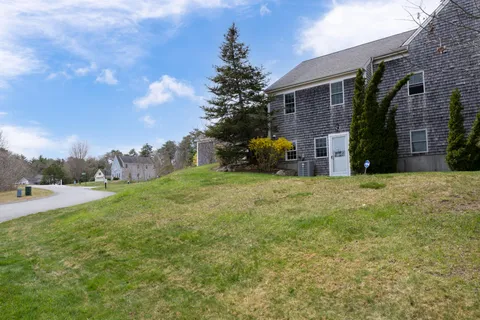 a view of a house with backyard and trees