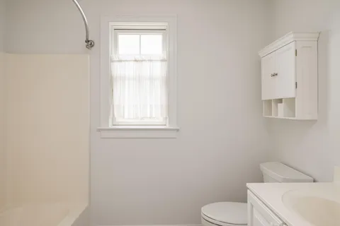 a white toilet sitting next to a bathroom sink