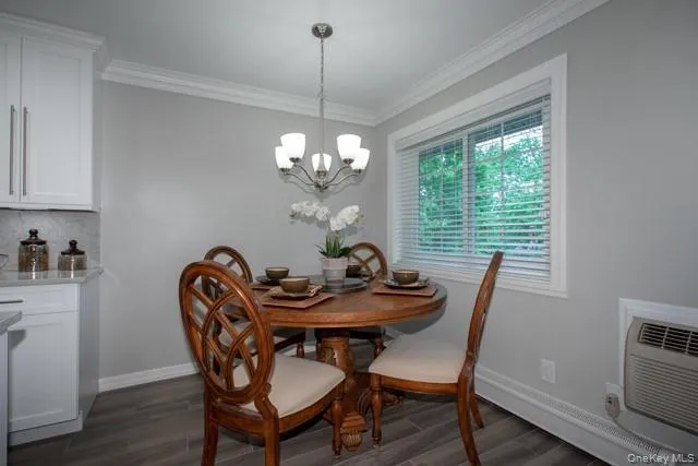 a dining room with furniture a chandelier and wooden floor