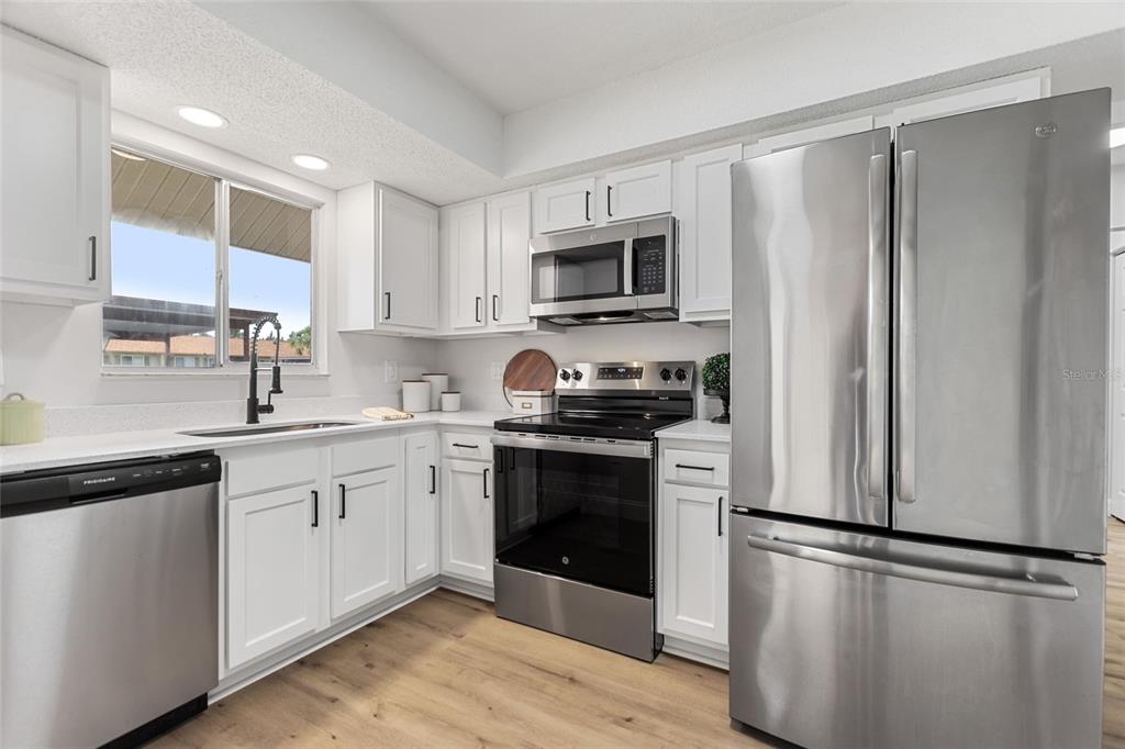 1950 Settlement Road, Unit 23 Venice, FL 34285 - Photo 13 of 33 a kitchen with stainless steel appliances a refrigerator sink and microwave