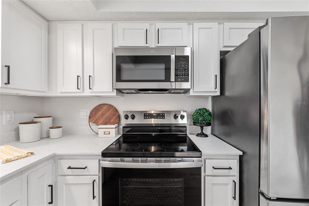 1950 Settlement Road, Unit 23 Venice, FL 34285 - Photo 14 of 33 a kitchen with stainless steel appliances granite countertop a stove microwave and refrigerator