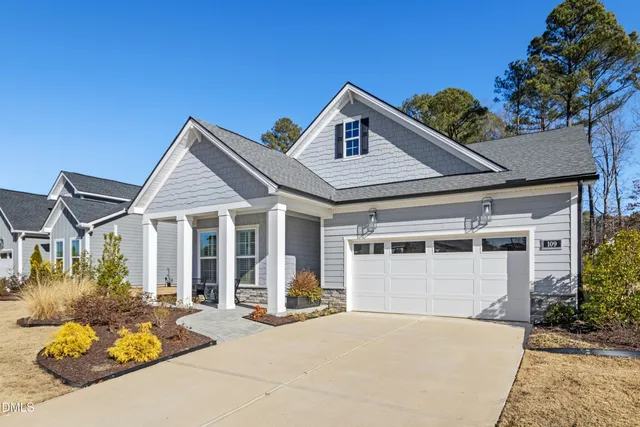 a front view of a house with a yard outdoor seating and garage