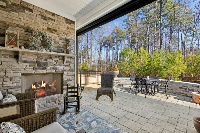 a view of a patio with table and chairs and potted plants with wooden fence