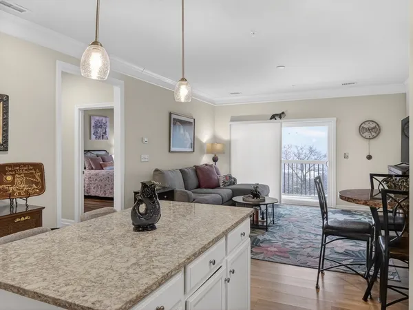 a kitchen with stainless steel appliances granite countertop a sink a stove a refrigerator cabinets and chairs
