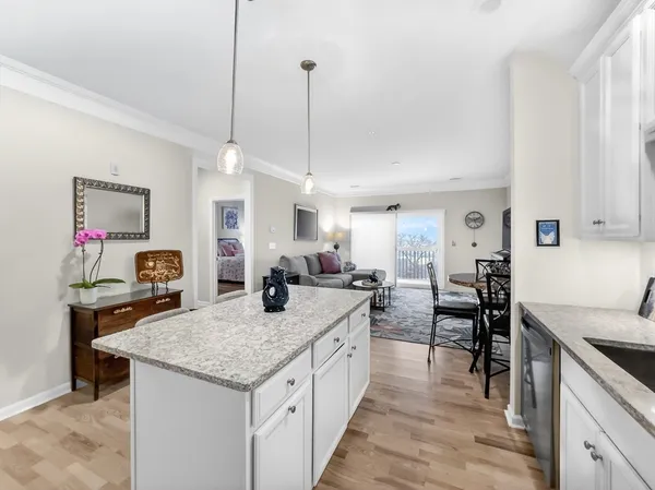 a view of a kitchen and dining table with granite countertop wooden floor
