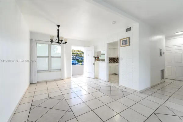 a view of a kitchen with white cabinets and refrigerator