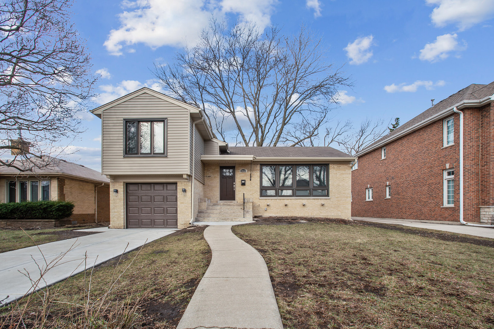a front view of a house with a yard and garage