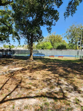 a view of pool with lawn chairs and plants