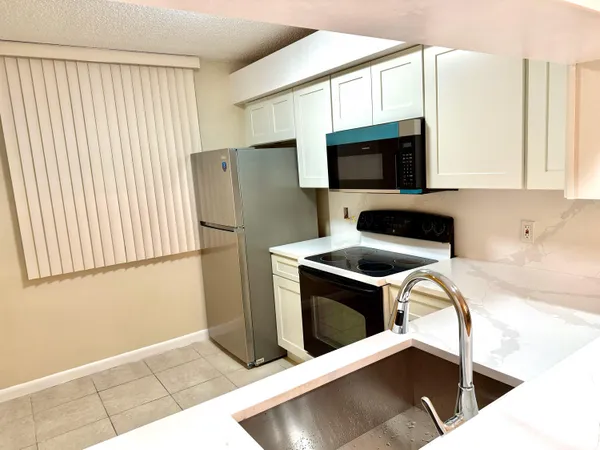 a kitchen with stainless steel appliances a stove a microwave and a refrigerator