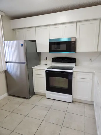 a kitchen with cabinets and steel appliances