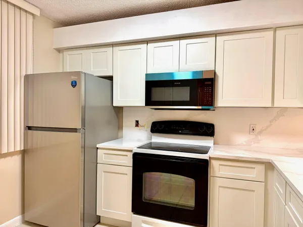 a kitchen with a refrigerator sink and cabinets